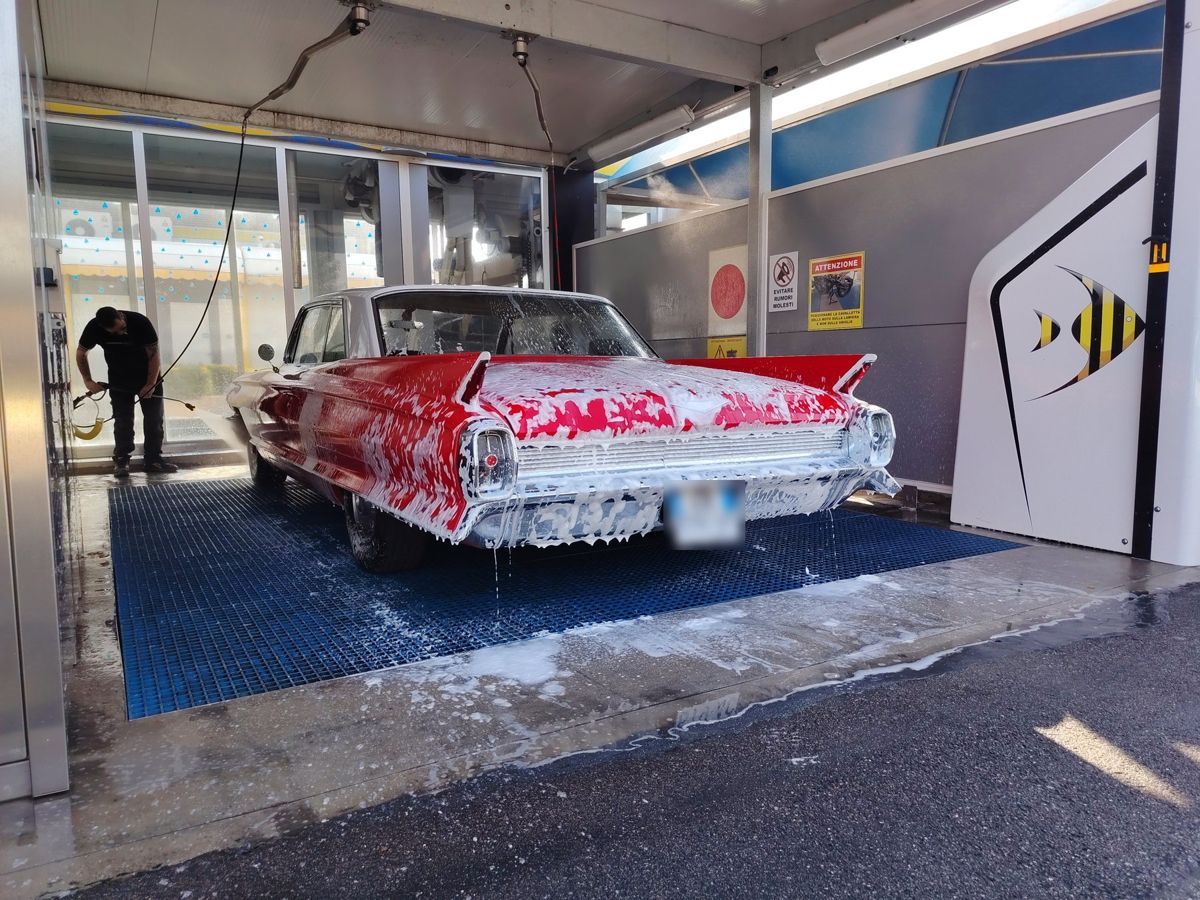 Una Cadillac rossa coperta di schiuma in pista